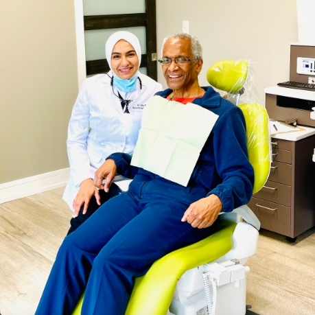 Doctor Khan smiling with periodontal patient in treatment chair