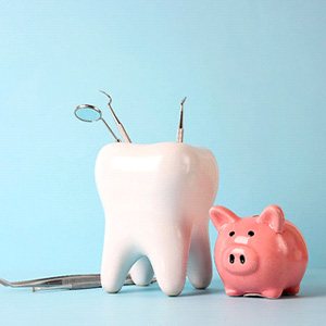 A pink piggy bank and tooth model against a blue background