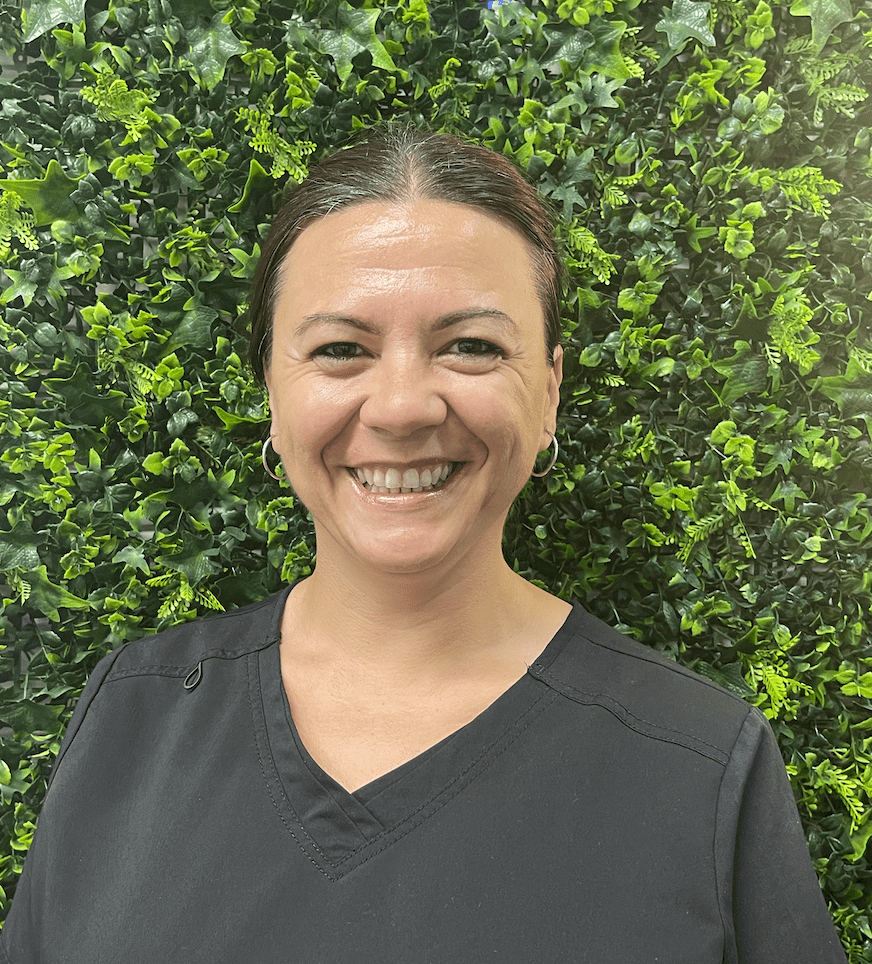 A woman standing in front of a green wall.