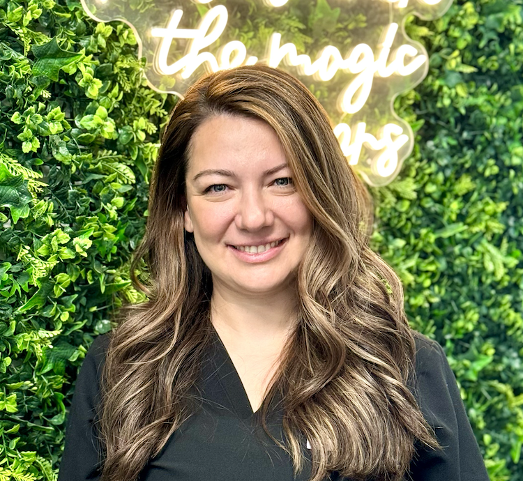 A woman standing in front of a green wall.