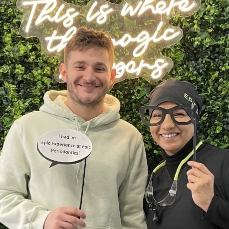 A man and woman posing for a picture in front of a wall.