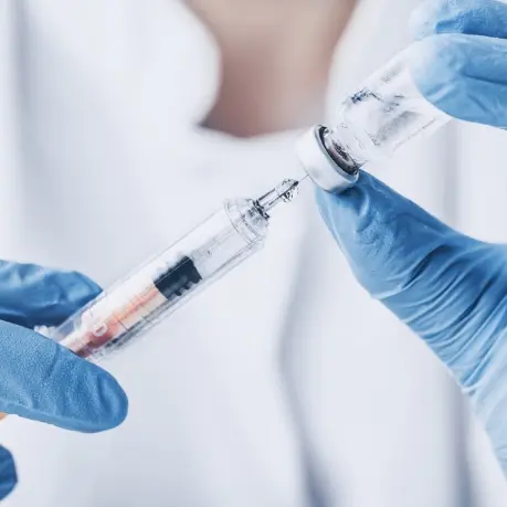 A person holding an injection in their hand.