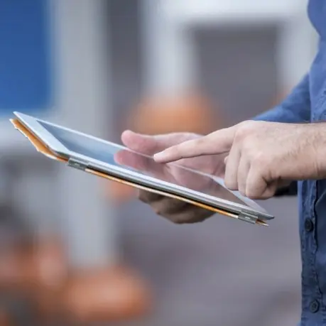 A person holding an ipad in their hands.