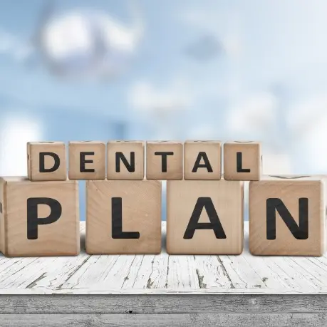 A wooden table with the words dental plan written on it.