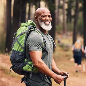 A man with a beard and backpack on hiking.