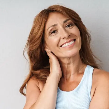 A woman with long red hair smiling for the camera.