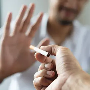 A man holding a cigarette in his hand.