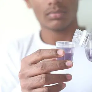 A man holding a container of liquid in his hands.