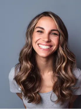 A woman with long hair smiles for the camera.