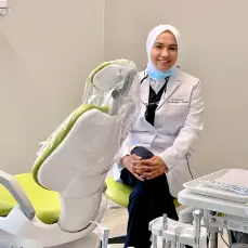 A woman sitting in front of a dentist chair.