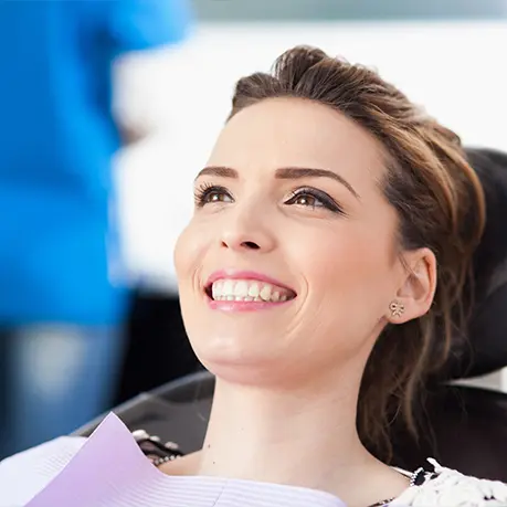 A woman sitting in the dentist chair smiling.