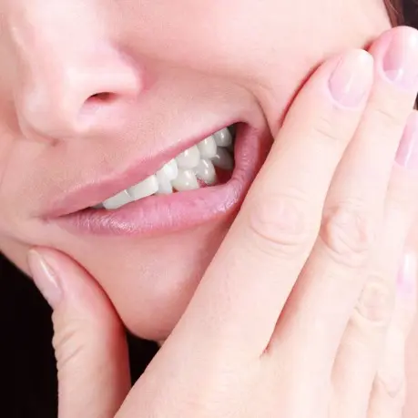 A woman with her hand on her face.