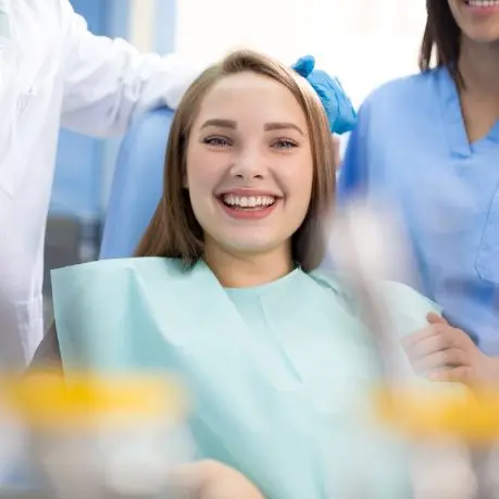 A woman sitting in the dentist chair smiling.